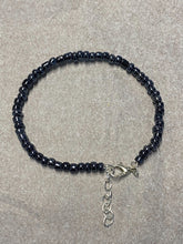 Load image into Gallery viewer, image shows a bracelet against light grey background. bracelet had a single band of dark grey metallic beads and a silver lobster clasp and extender chain
