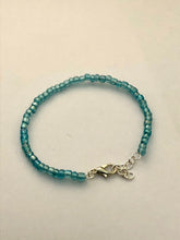 Load image into Gallery viewer, image shows a bracelet against light grey background. bracelet had a single band of light blue beads and a silver lobster clasp and extender chain
