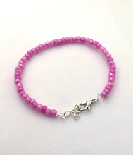 Load image into Gallery viewer, image shows a bracelet against light grey background. bracelet had a single band of solid pink beads and a silver lobster clasp and extender chain
